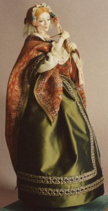 An imaginary figure from the Victorian age with paisley shawl and silk gown, fastens the strings of her velvet bonnet before going for a walk. Note her gloves, sculpted onto her delicate hands. Emma Rose